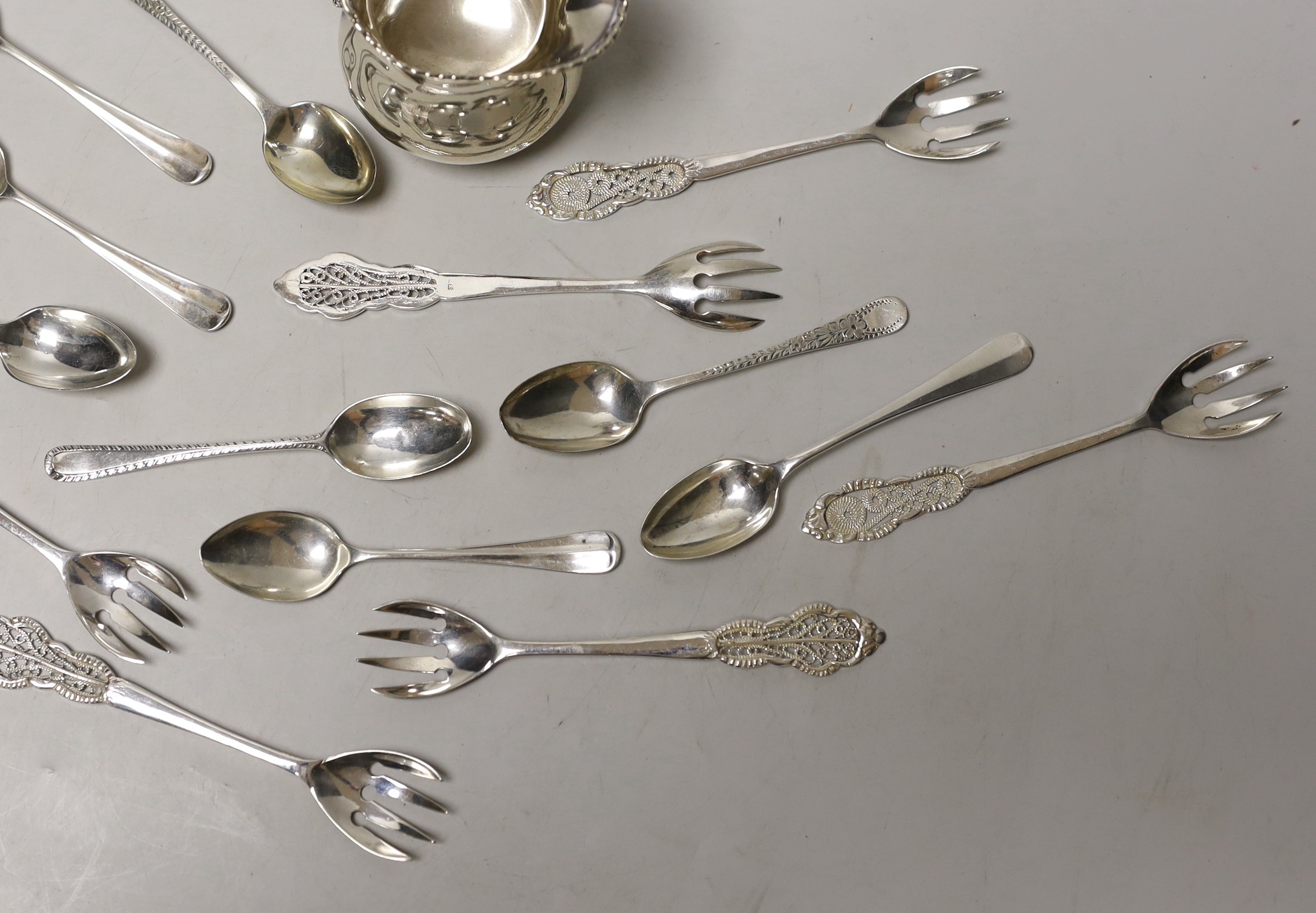 A silver cream jug and sundry minor spoons and forks.